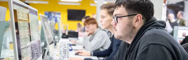 A male student looking at a computer monitor