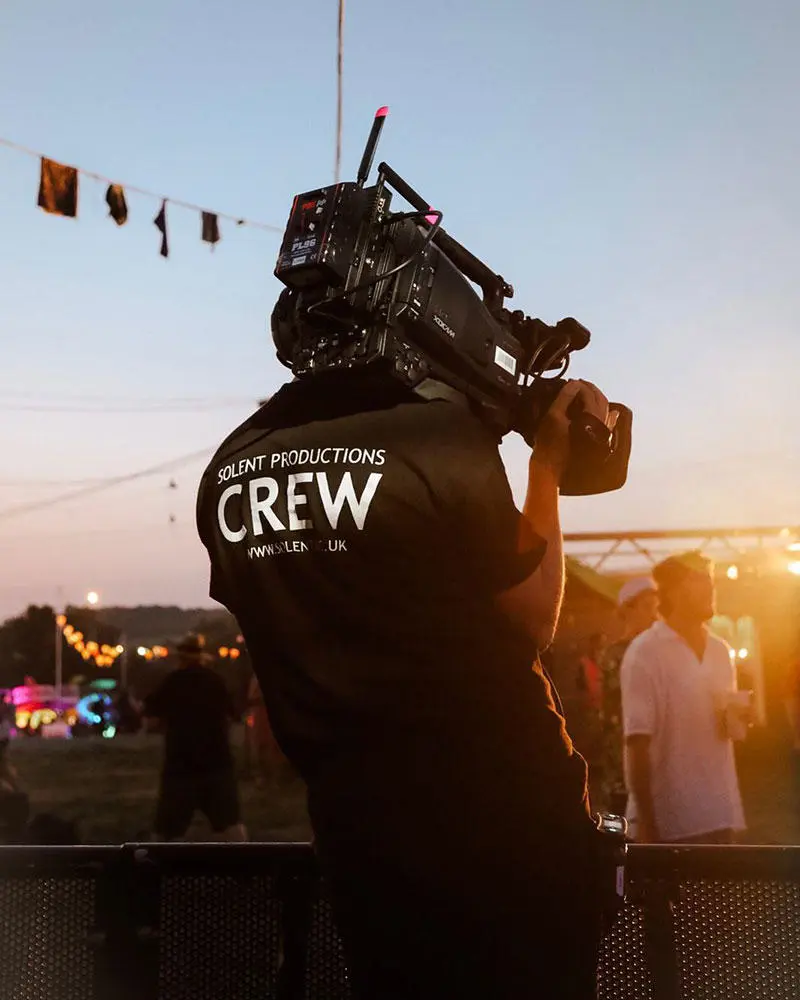 A Solent Productions student holding a camera at Glastonbury Festival