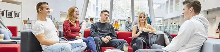 A group of students sitting down in the Spark, talking to each other