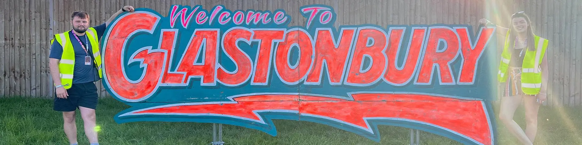 Image of two students standing next to Glastonbury sign