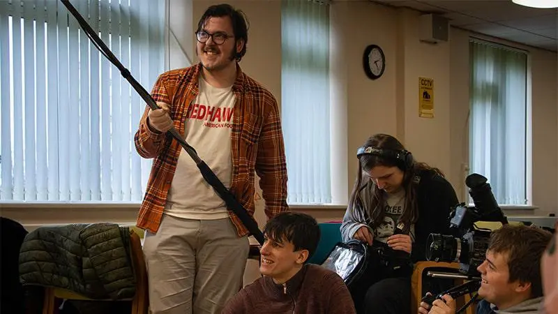 A group of students sit together with cameras.