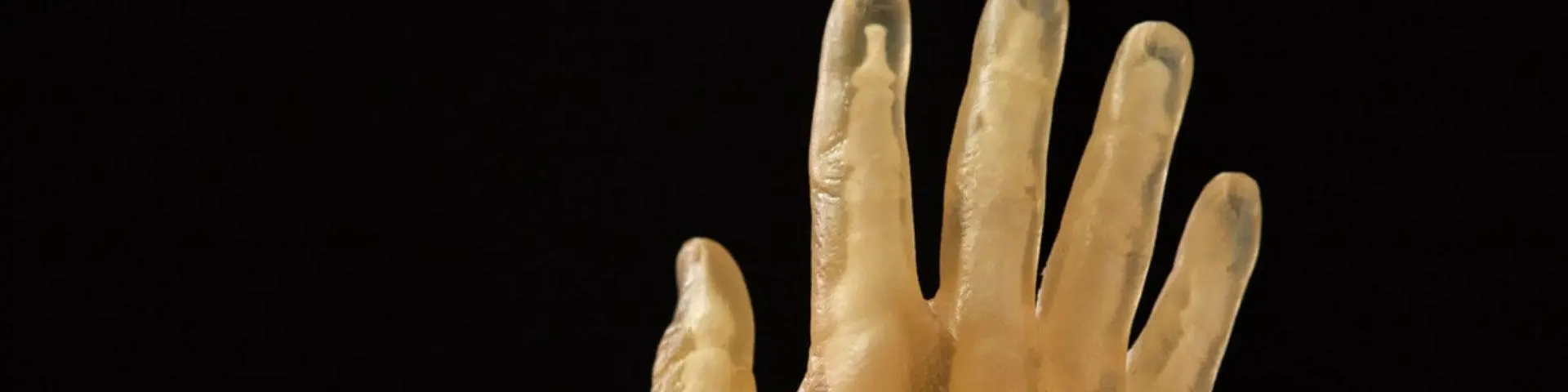 A computer rendered yellow hand on a black backdrop.