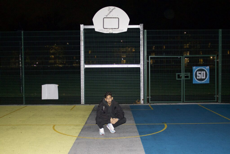 Avi at a basket ball court, outside. 