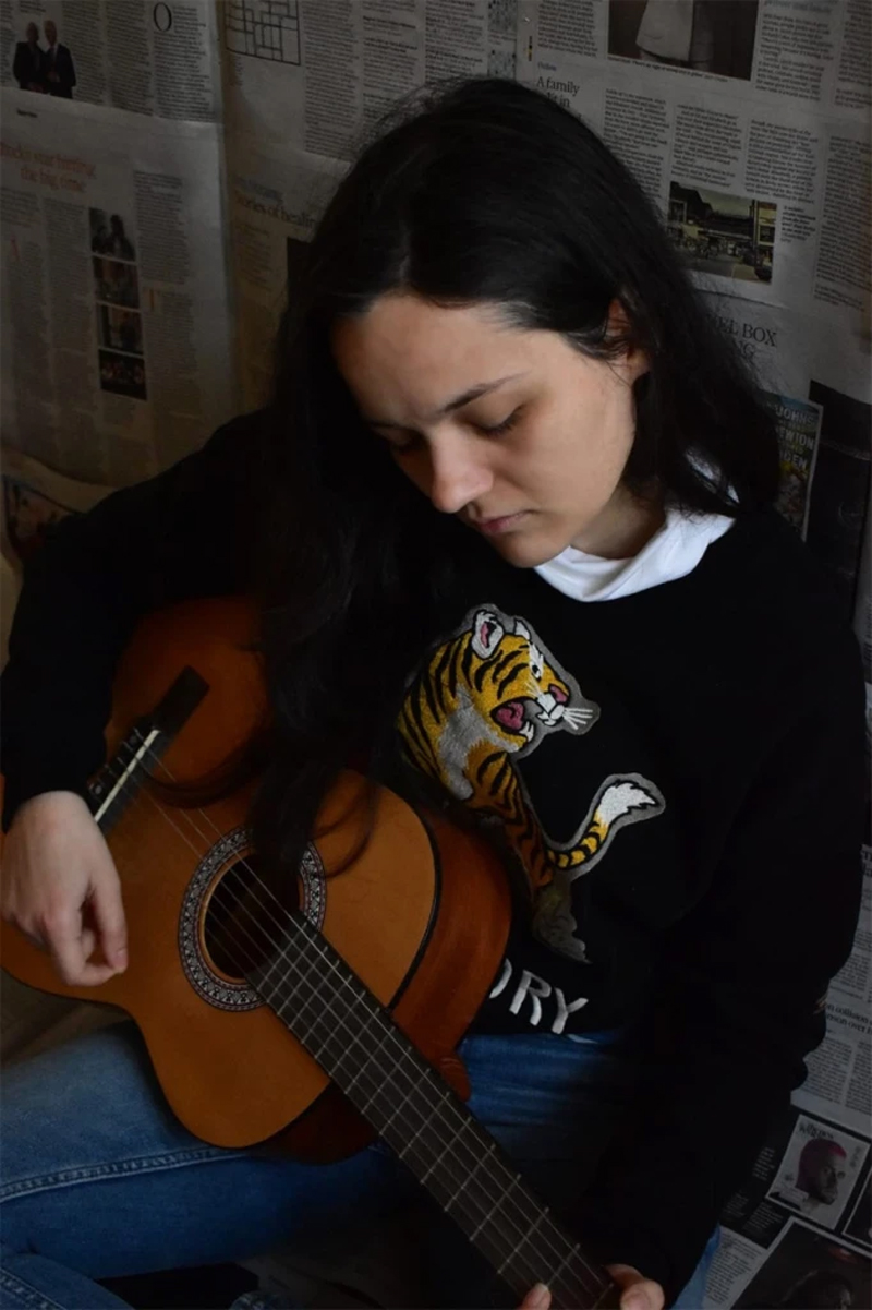 Lara playing her guitar