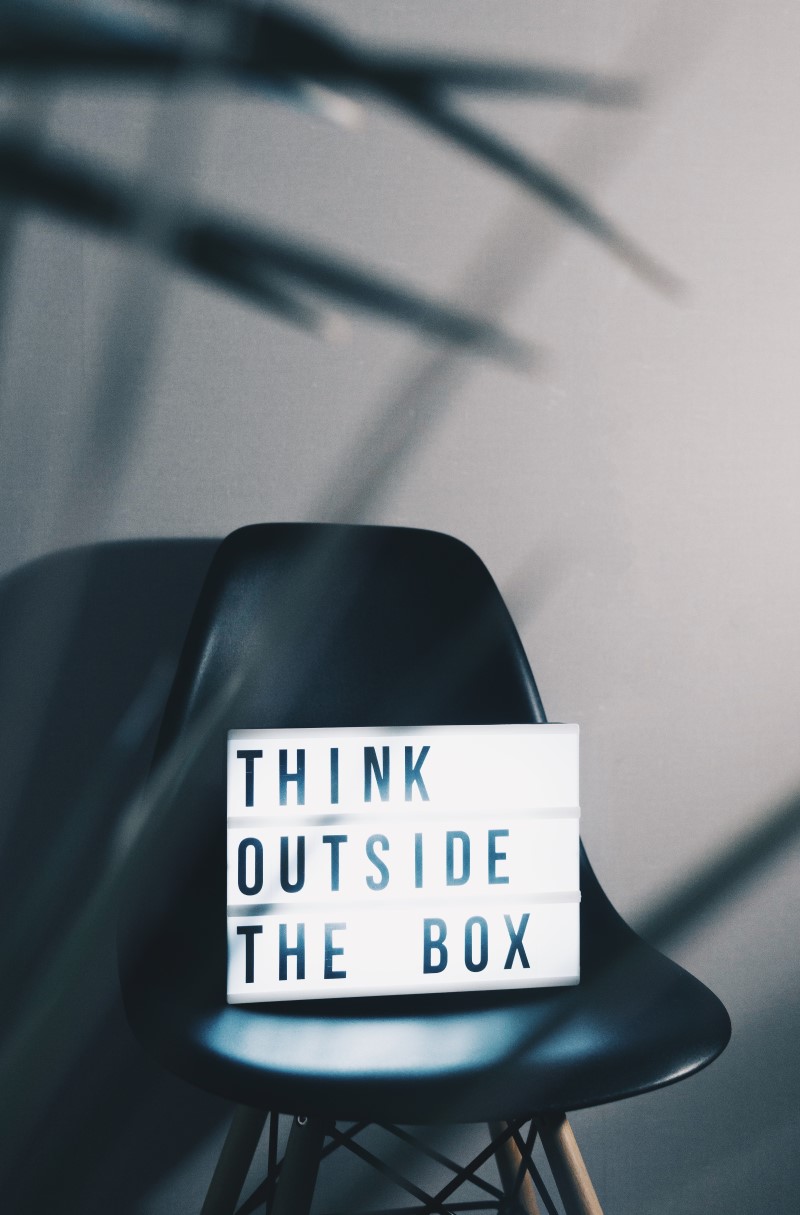 A chair with a lit up sign on it saying 'think outside the box'