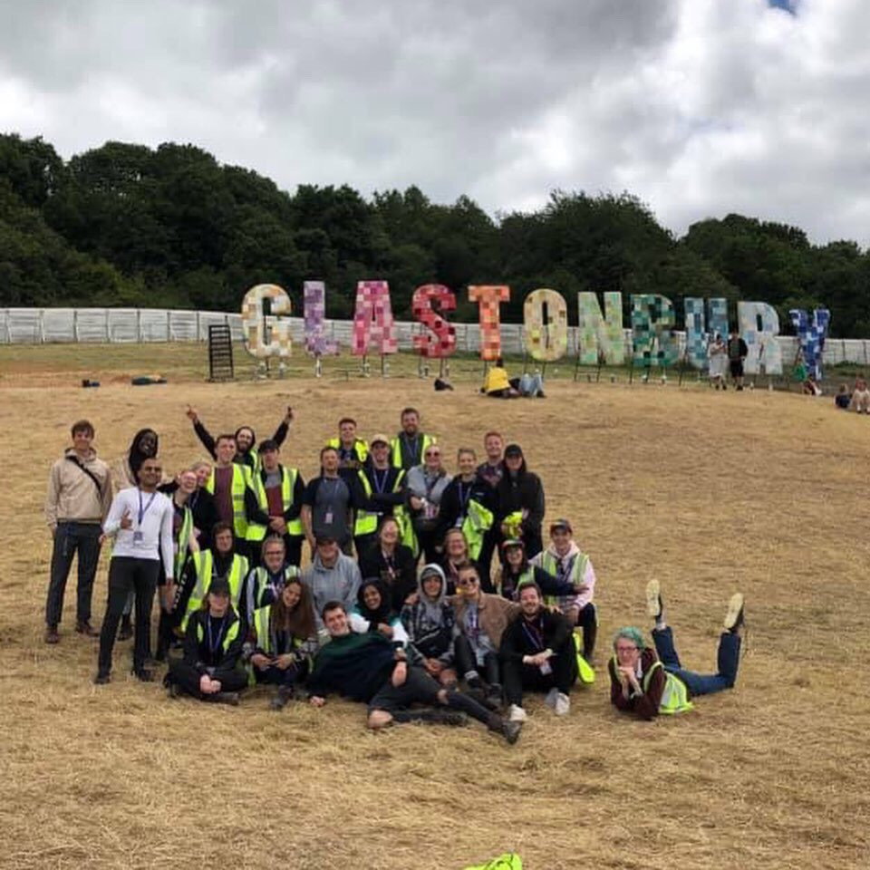 The team at Glastonbury in front of the famous sign