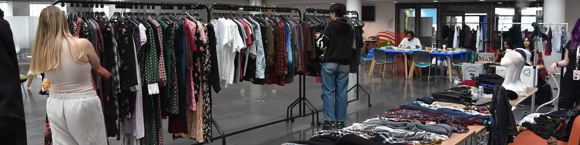 Students looking through clothes rails in The Spark. 