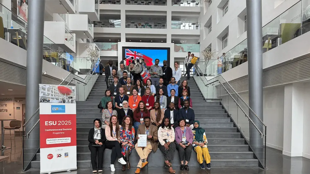 A group photo of conference delegates sat together on the stairs in The Spark.