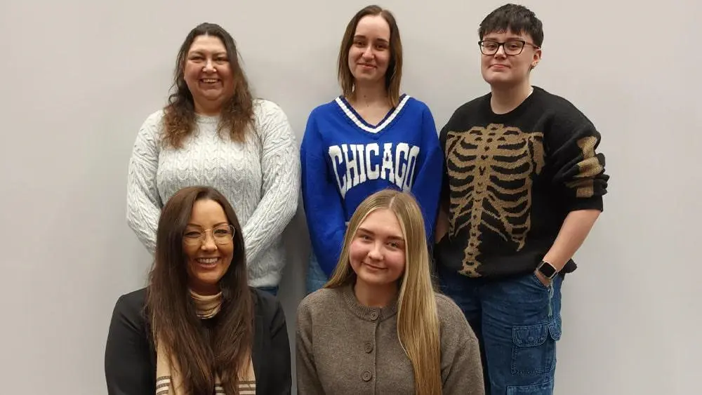 Five criminology students stood together in front of a white wall.