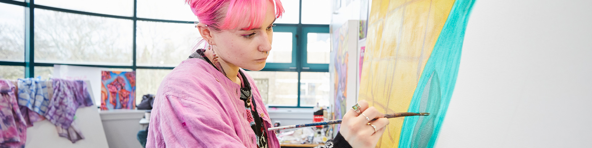 A fine art student painting on a canvas.