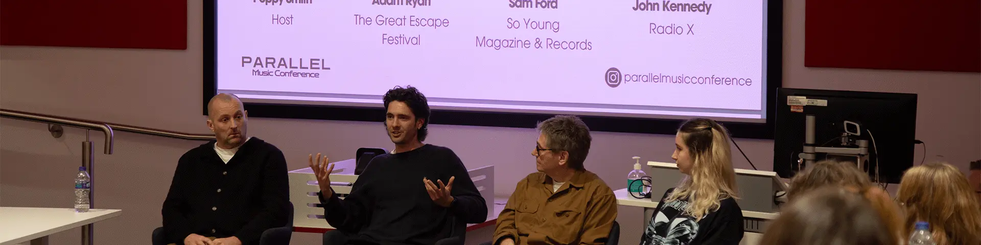 A panel of people sit together in a lecture theatre at Solent University. 