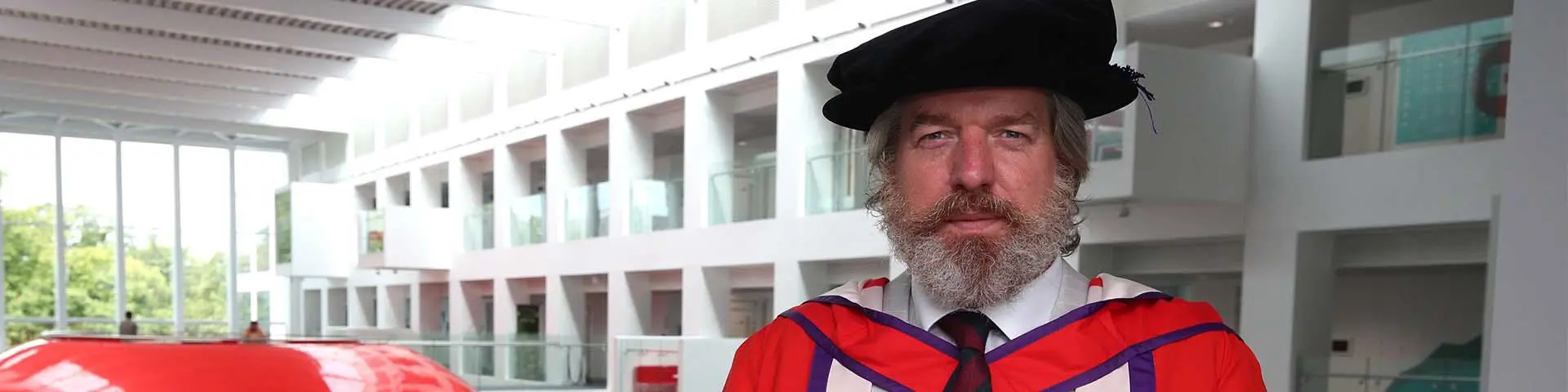 Phil Packer in his honorary doctorate gown in The Spark building