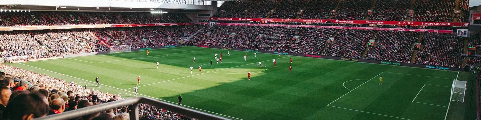 Two teams playing football in a stadium.