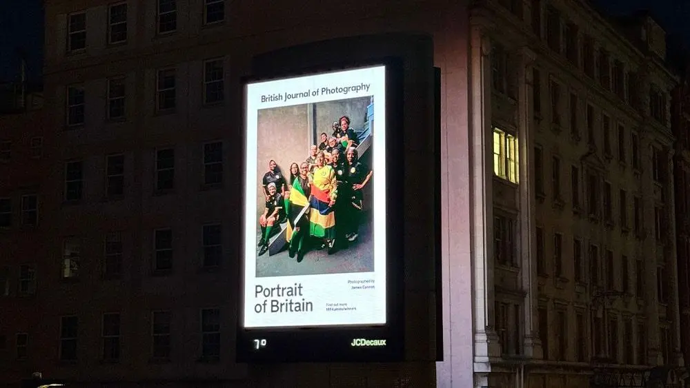 A billboard of The Steppers, a Portrait of Britain winning photograph, on the side of a building.