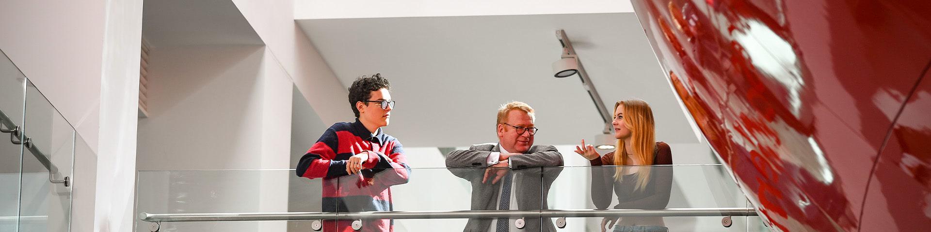 Two students with the Vice-Chancellor on the bridge of The Pod.