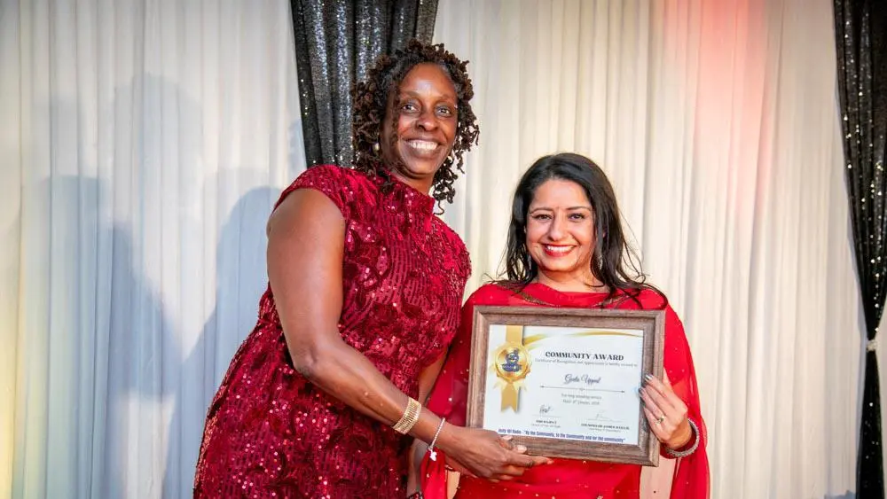 Geeta receiving her award from Jenni Douglas-Todd