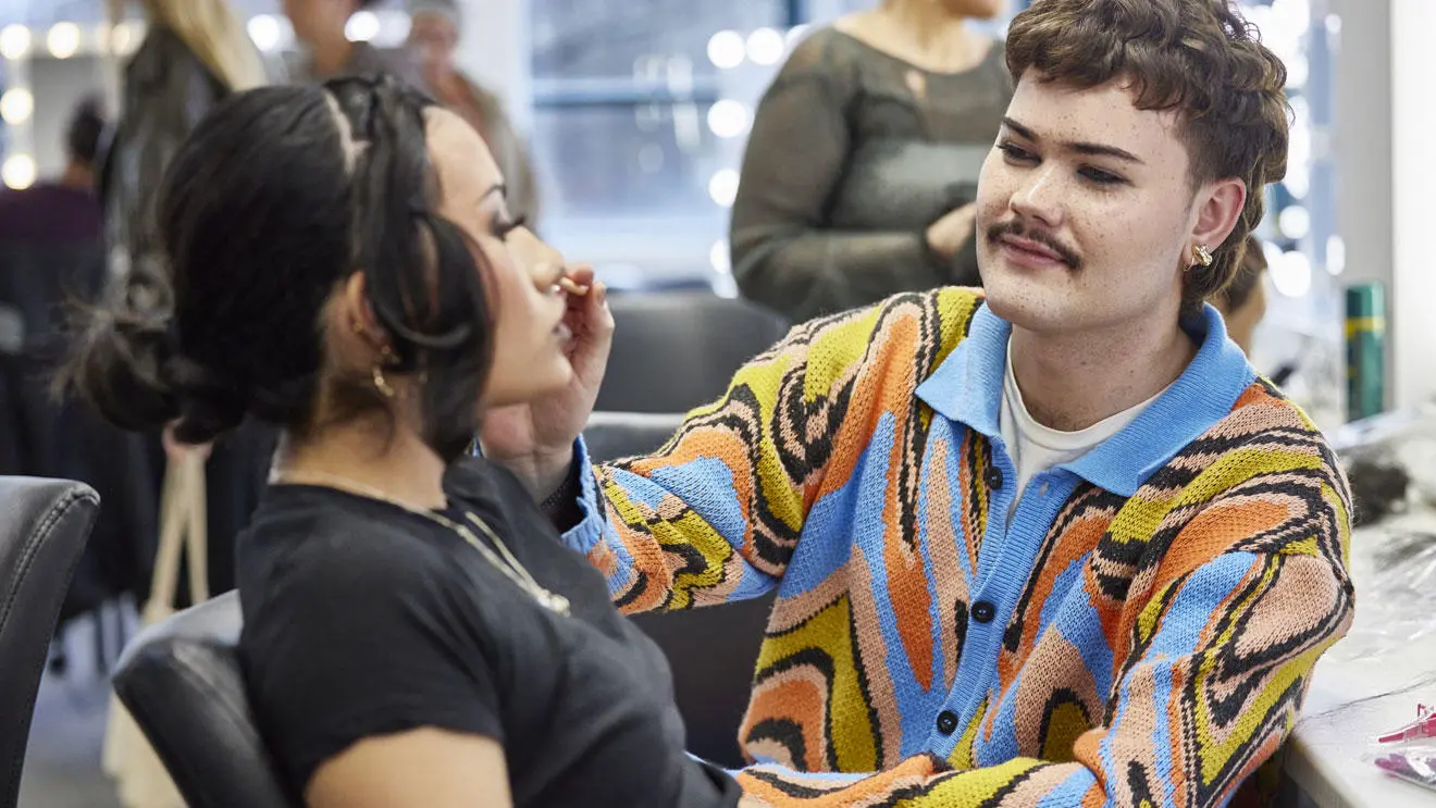 A make-up student working on a model