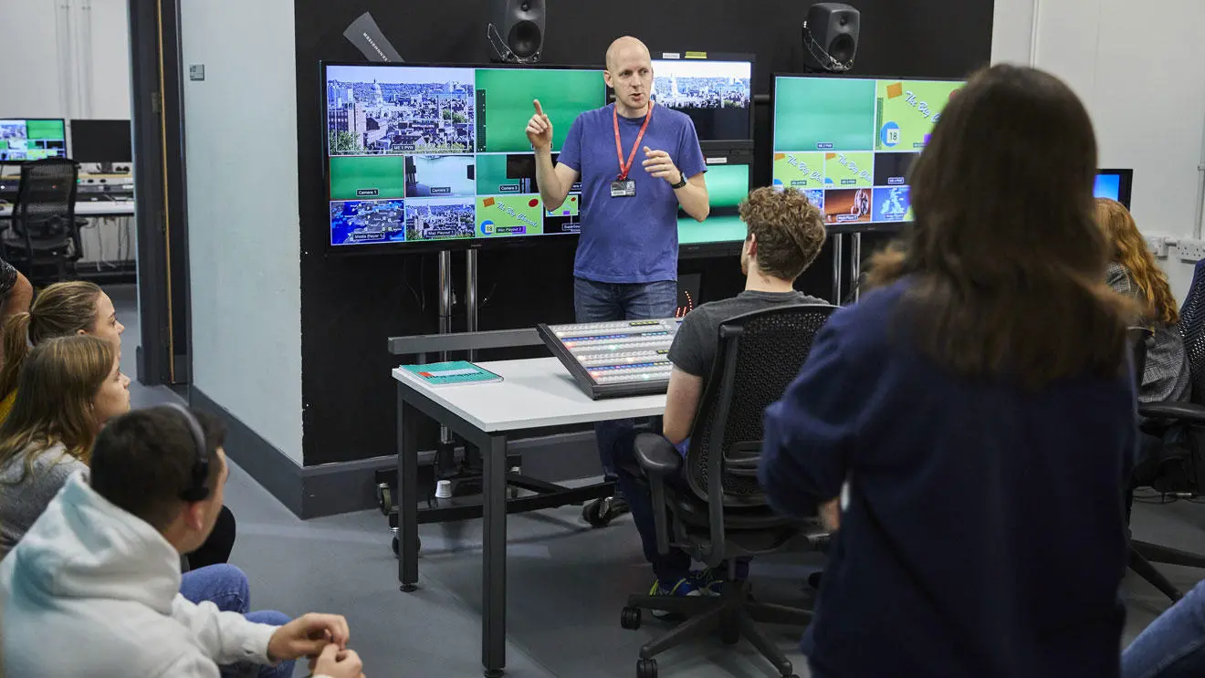 A media technician showing students the editing facilities