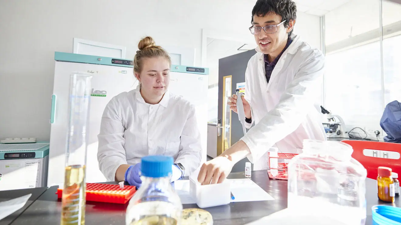 Biomedical science student with a lecturer in the lab