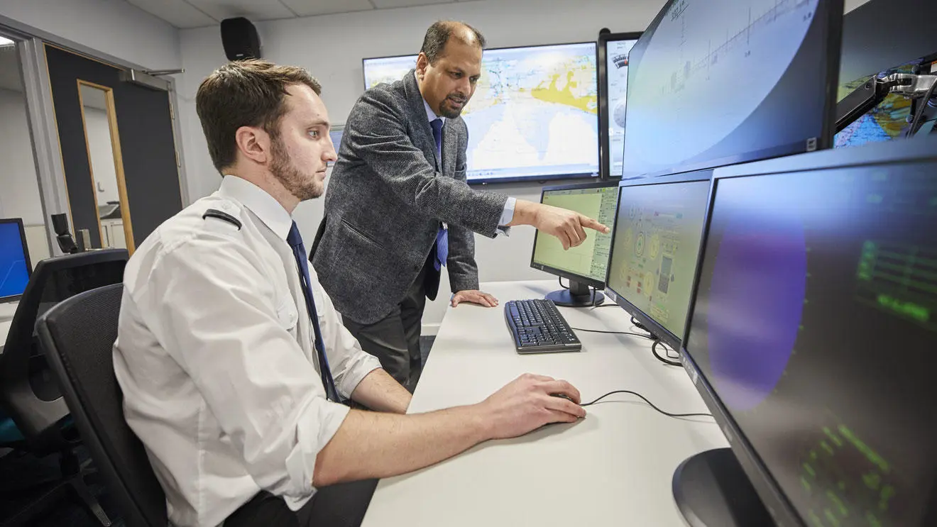 A deck cadet in the ECDIS suite with an instructor