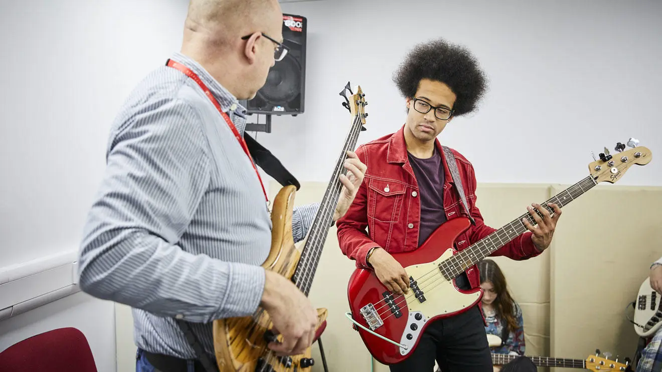 A music performance student playing bass guitar