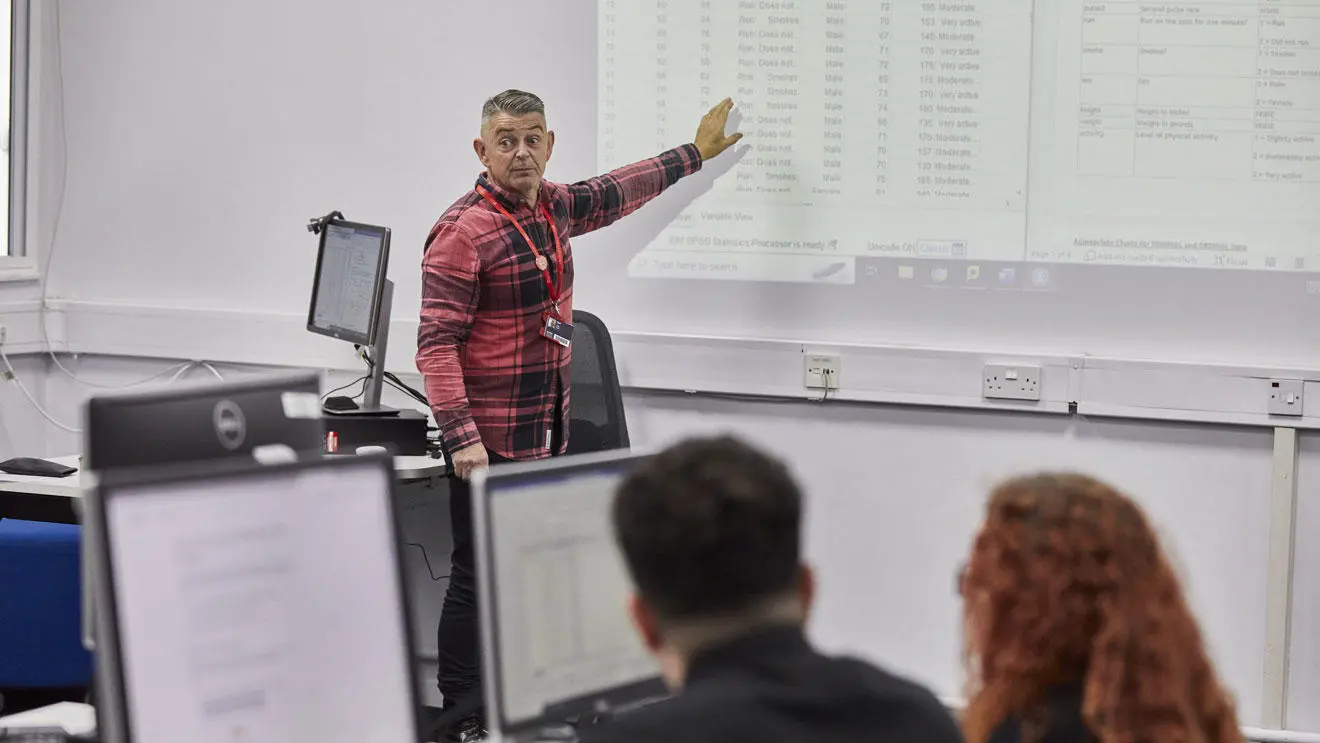 A psychology lecturer talking to students in the classroom