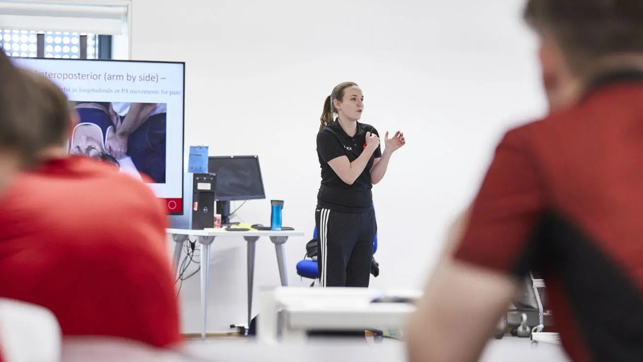 A sports therapy lecturer giving a demonstration