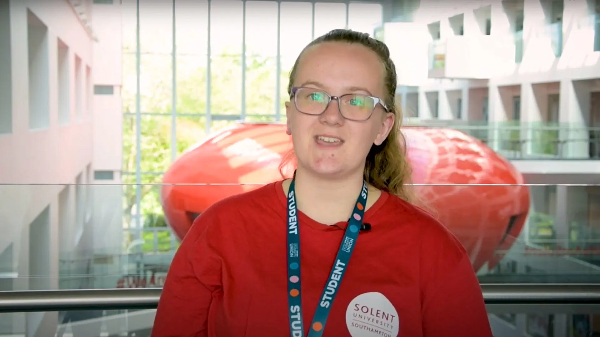 Screenshot of Solent student, Amy talking to camera in front of the Pod