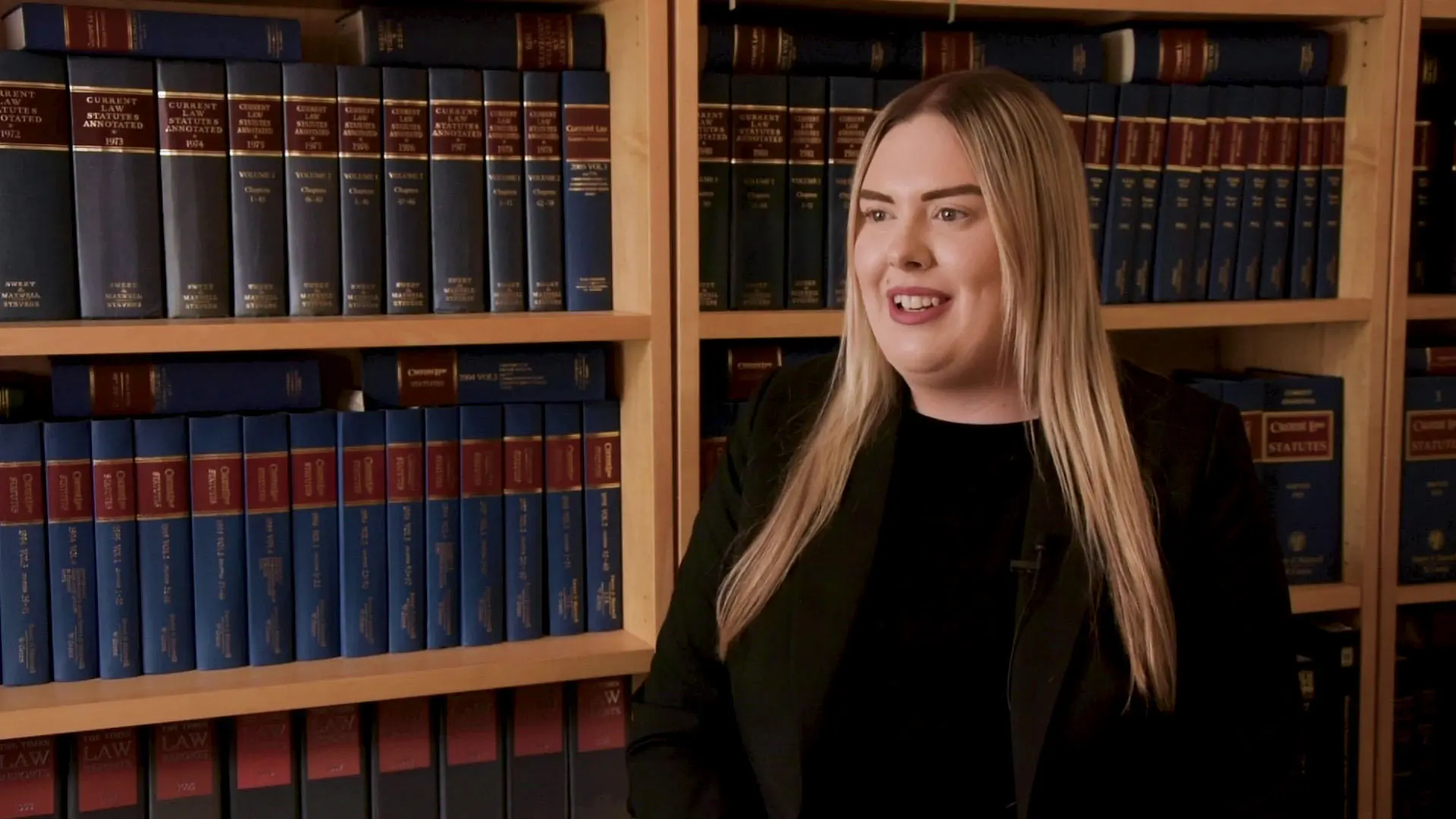 Paige Symns in an interview with law books in the background