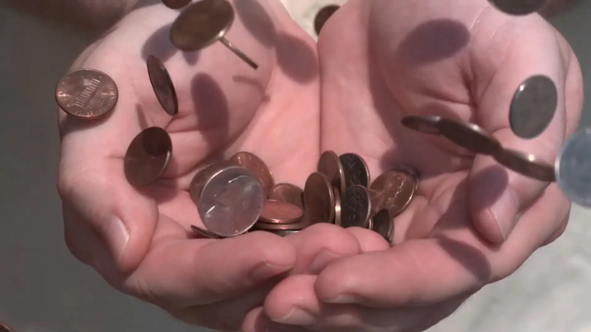 Coins falling into outstretched hands