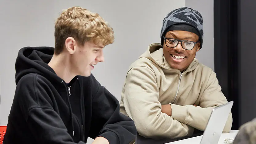 Two people working at a laptop