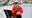 A female seafarer photographed from behind. She is wearing orange PPE.