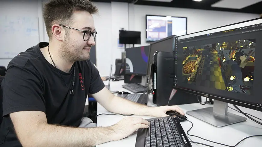 A games student working on a desktop computer