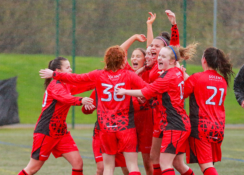 Solent's women's football team players celebrating