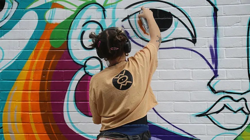 An artist painting a drawing on a wall