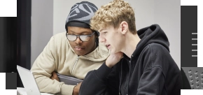 Two students looking at a laptop