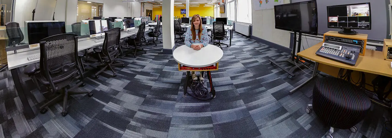 A student sat at a table in the newsroom